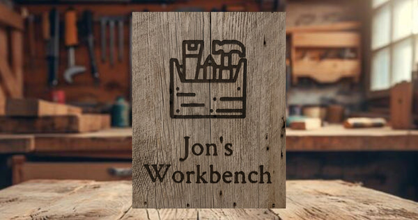 Wooden sign with 'Jon's Workbench' engraved on a workshop background